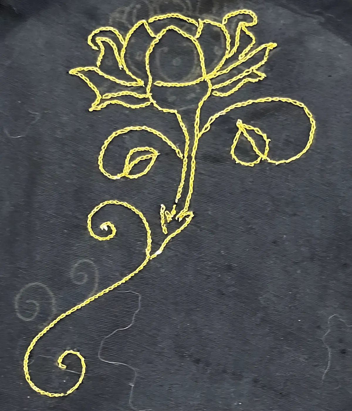 Aari embroidery: a gold chain-stitch rose on black