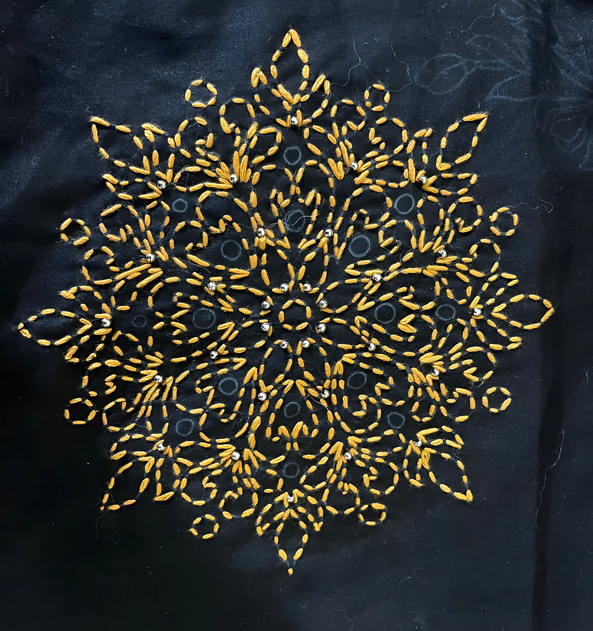 Embroidered mandala in gold thread on black