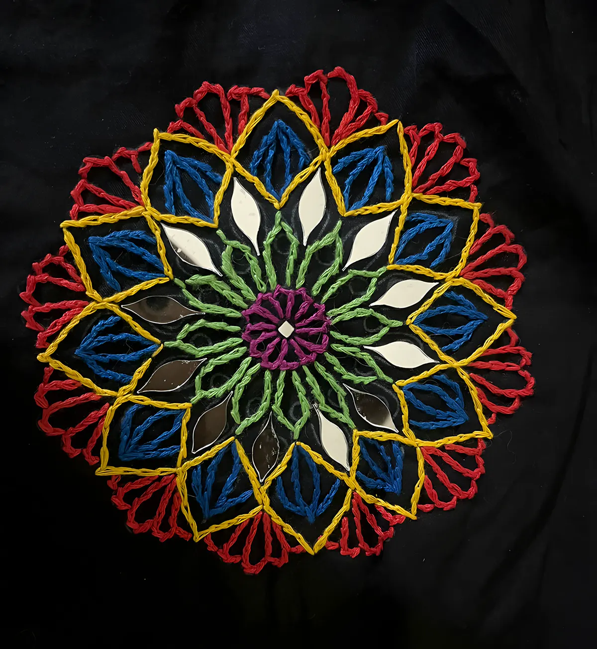 Embroidered mandala in red, yellow and green on black