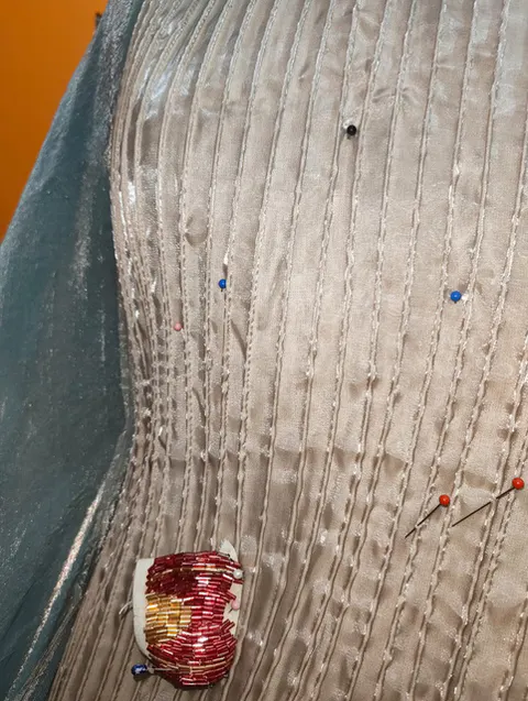 Pin-tuck channels with a hand-embroidered marine motif